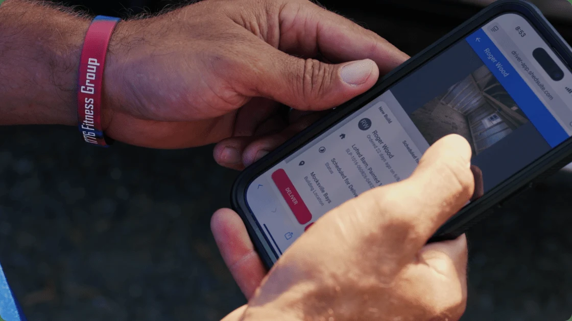 A Liberty Sheds driver using the Shed Suite app on a phone