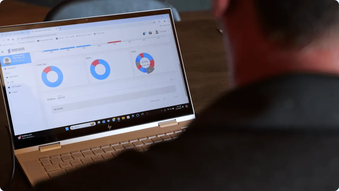 A Stor-Mor team member reviewing Shed Suite reporting dashboards on a laptop